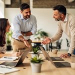 Espace de coworking lumineux à Lorient, où deux femmes et deux hommes échangent autour d’une table de travail dans une ambiance professionnelle et chaleureuse.