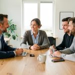 Deux hommes et une femme échangent autour d’une table dans un espace de travail moderne et lumineux à Lorient.